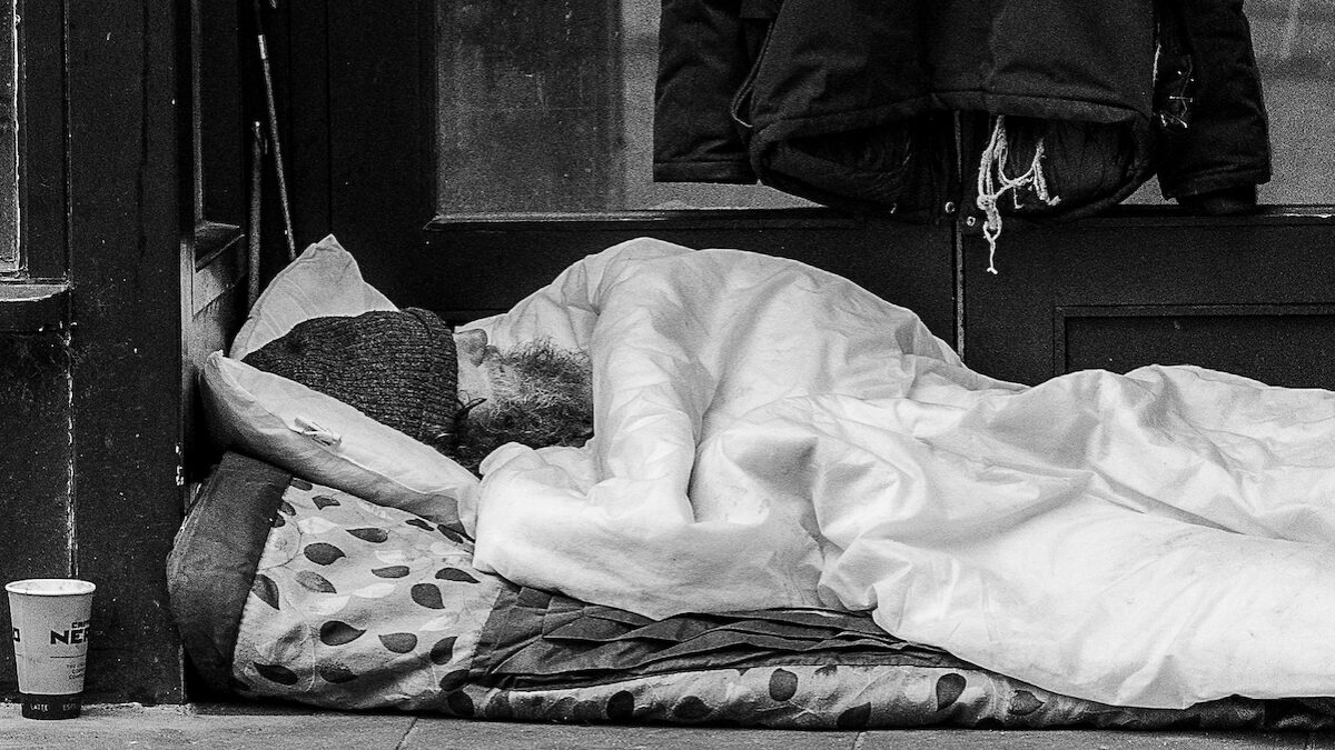 Homeless man sleeping in doorway.