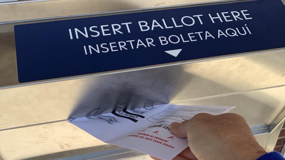 A ballot being dropped into a ballot drop box.