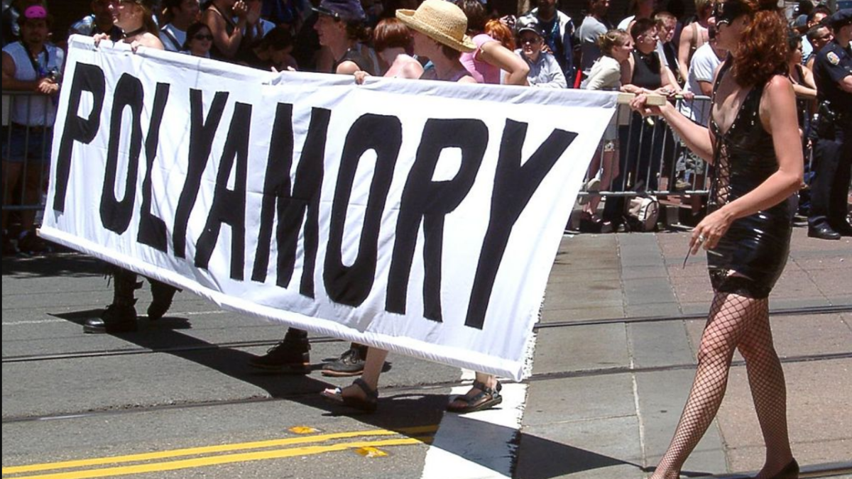 protesters marching with a "polyamory" sign