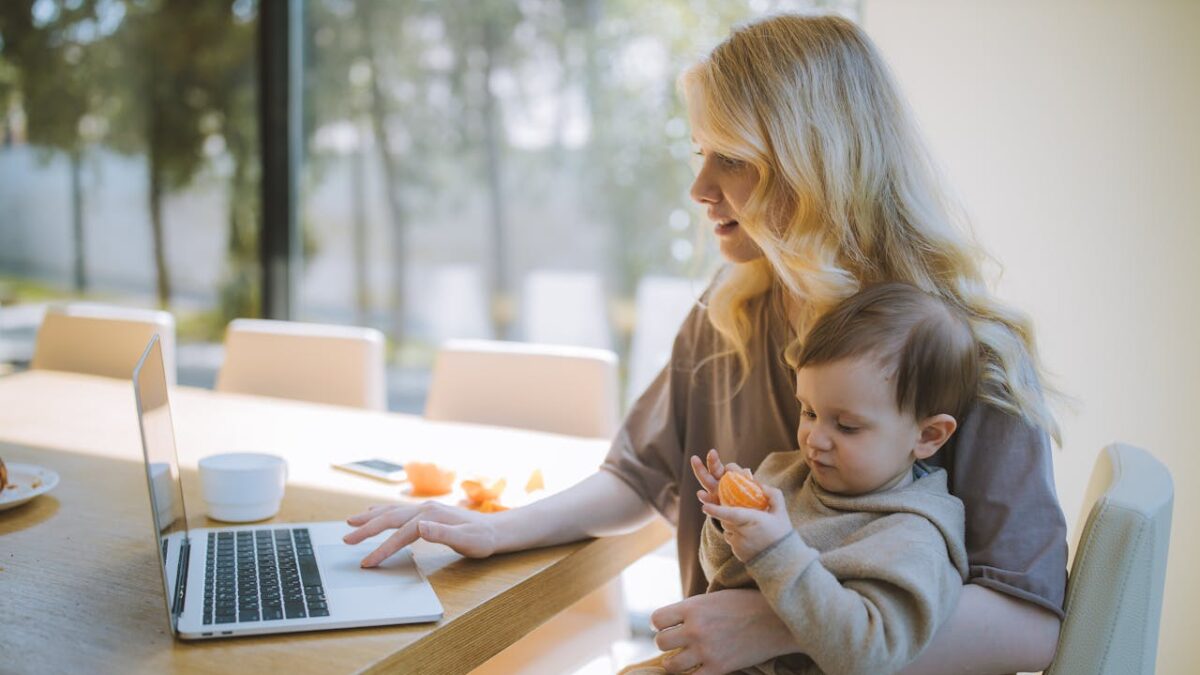 mom working on laptop with baby in lap