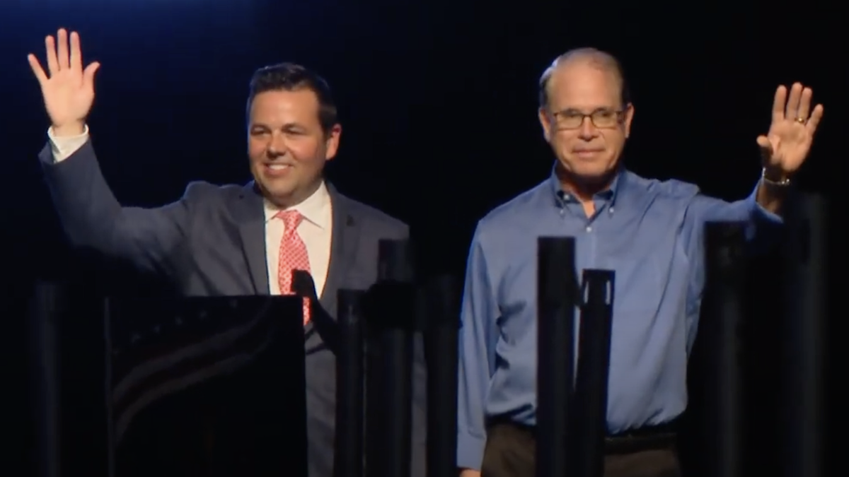 Micah Beckwith and Mike Braun are standing on stage and waving.