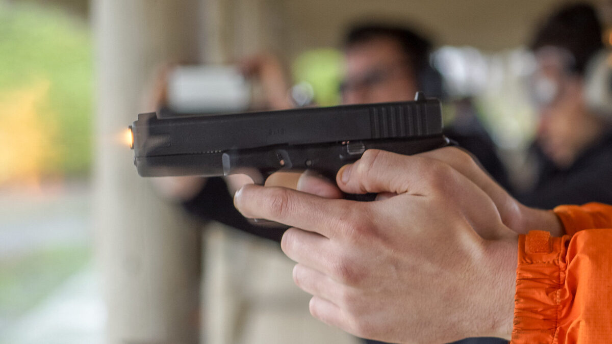 Firing handgun at gun range.