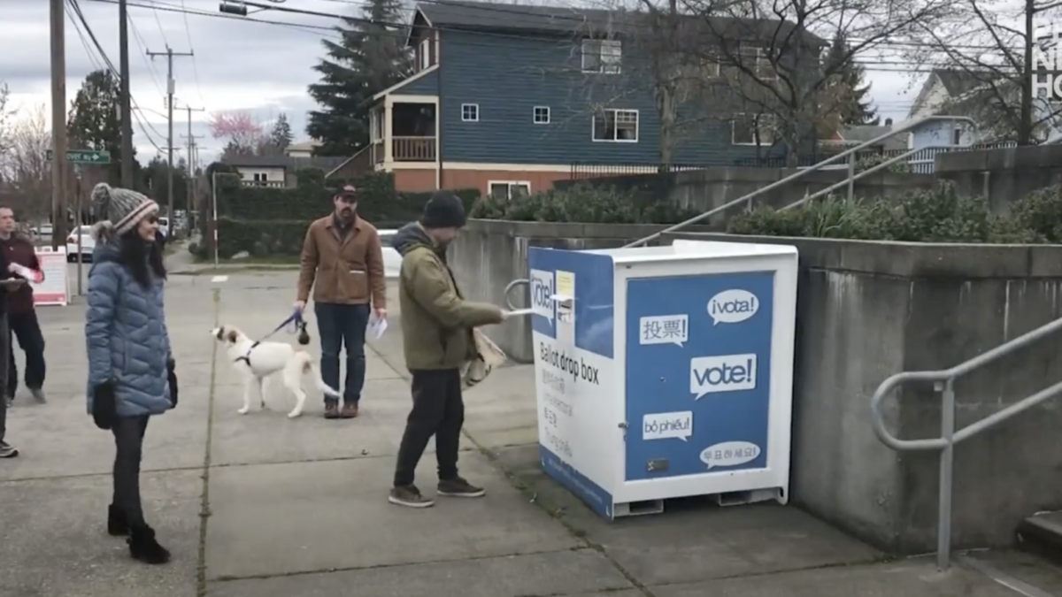 Voters drop ballots in outdoor ballot drop box.