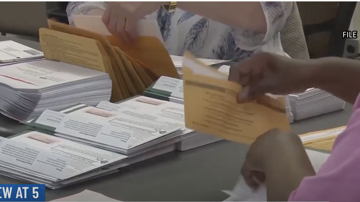 Election official handles absentee ballot.