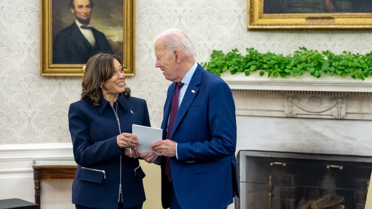 Kamala Harris and Joe Biden hold a piece of paper