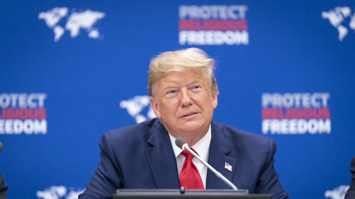 Donald Trump in front of protect religious freedom banner