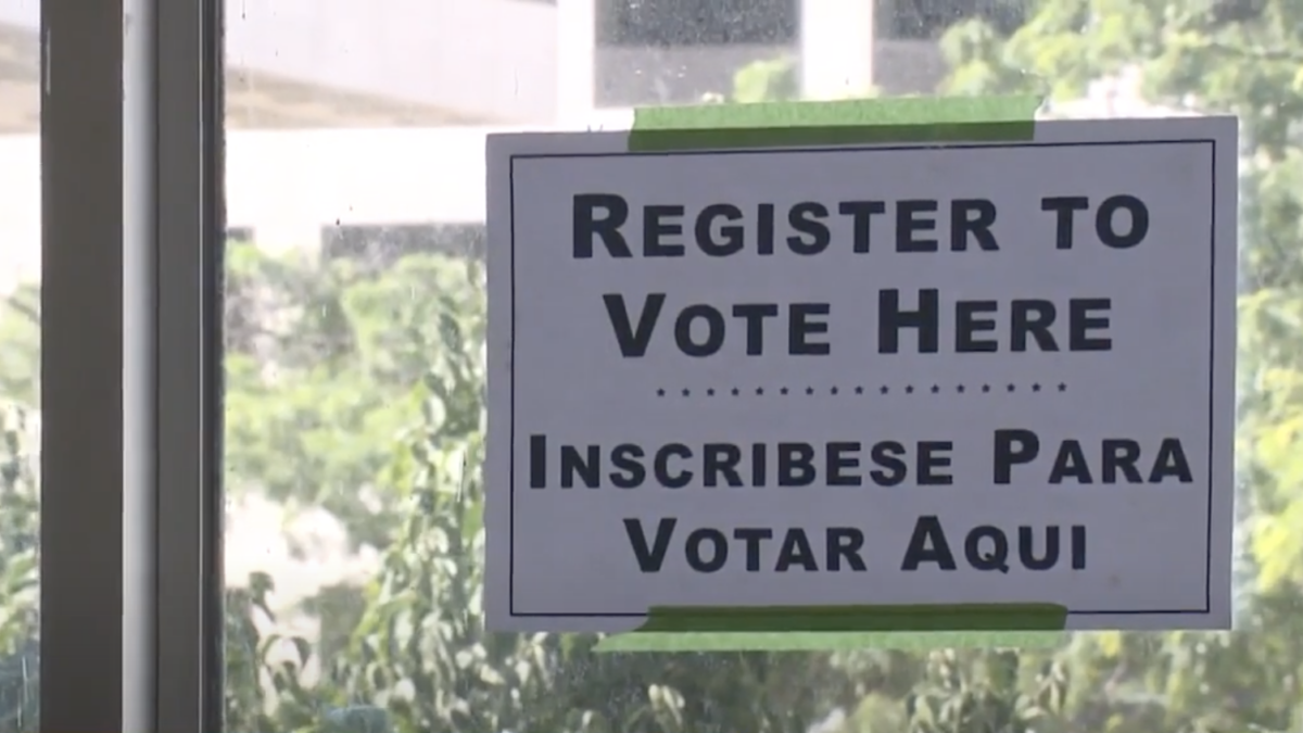 Sign at Milwaukee elections office notifying voters where to register.