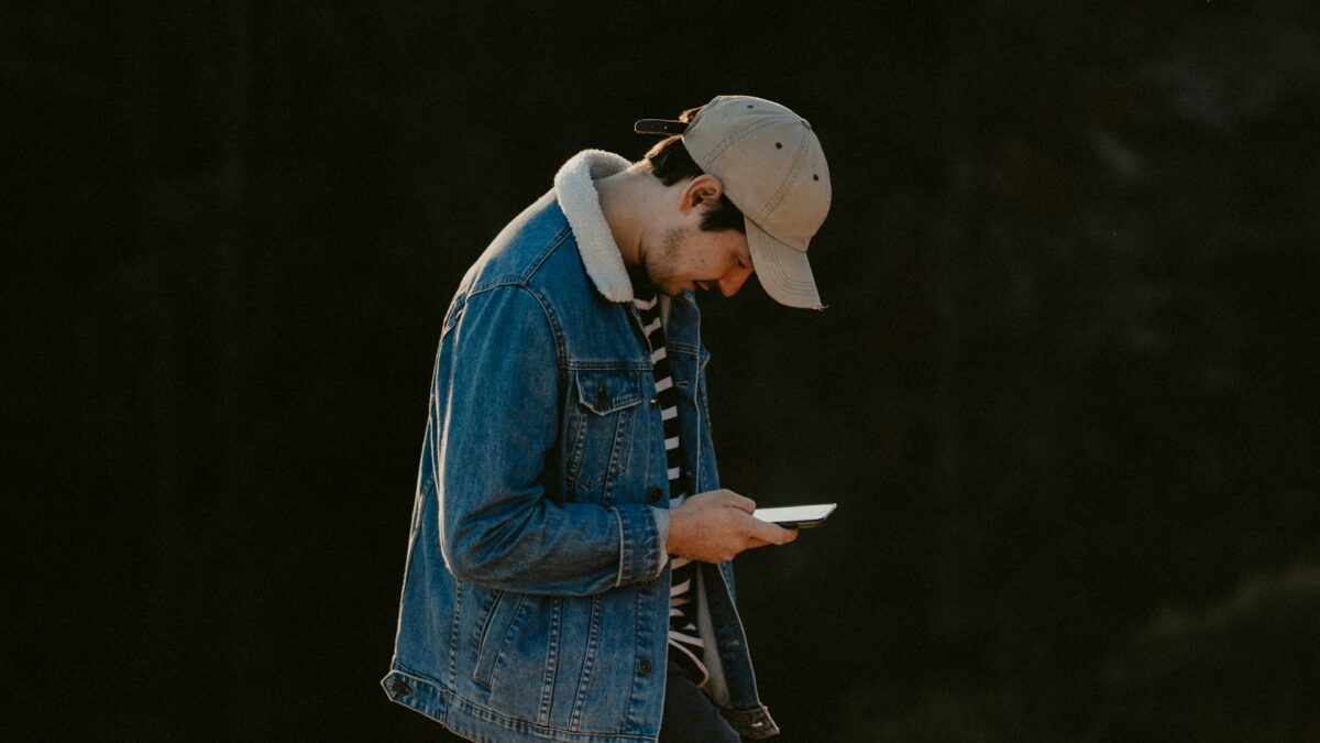 Teenage boy in nature but on his iPhone