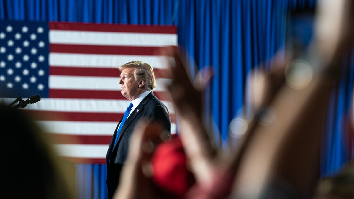 Donald Trump stands in front of American flag