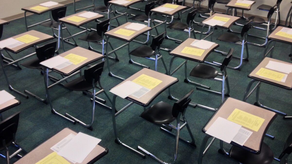 desks in classroom with testing materials laid out