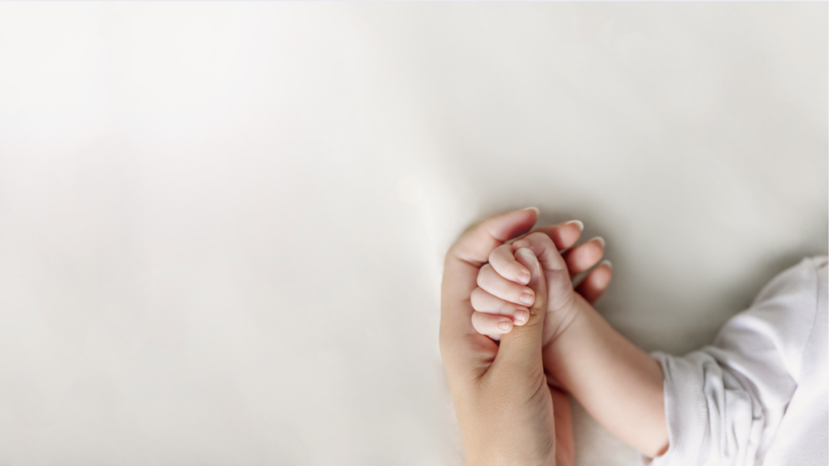 mom holding baby hand