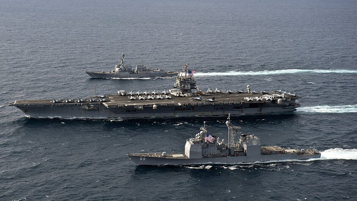 Navy ships moving across the ocean.