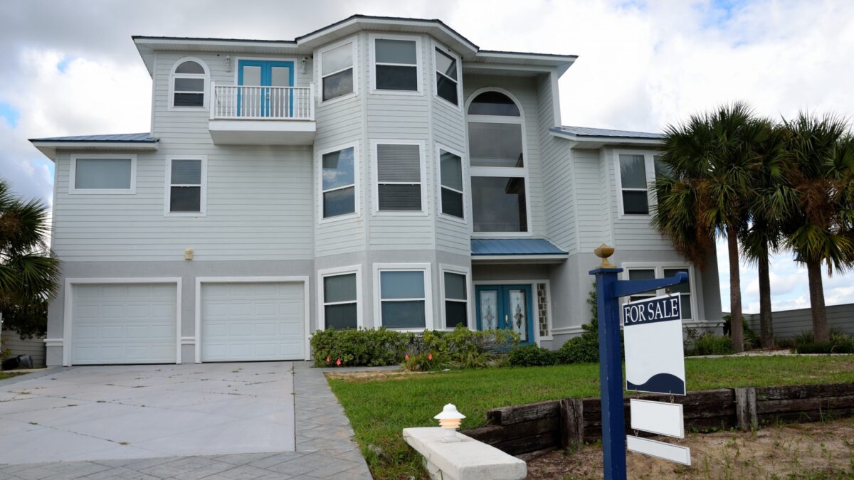 a house in florida with a for sale sign in the yard