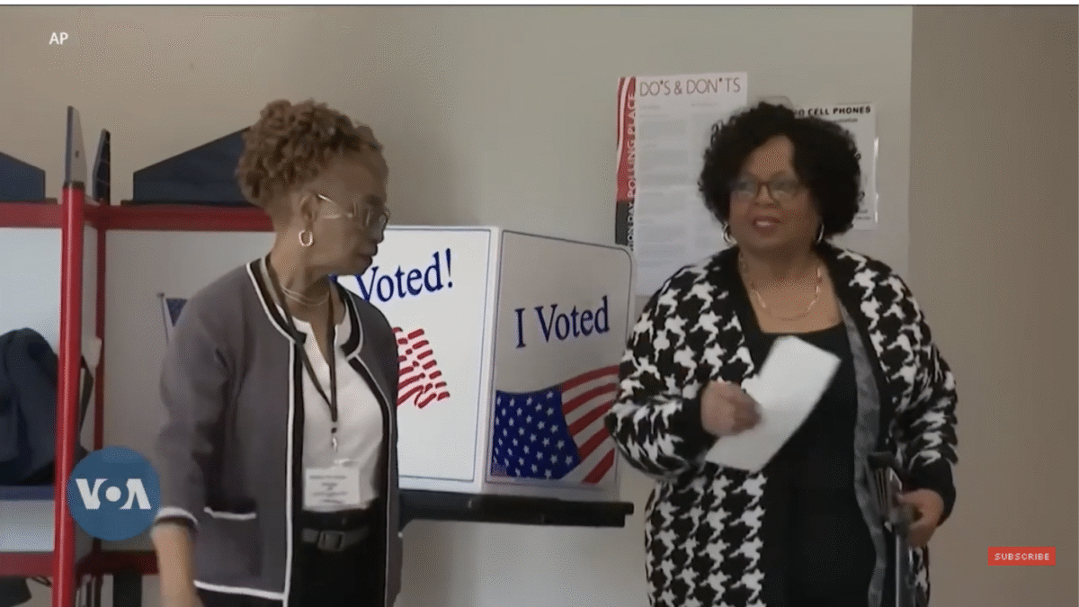A black woman prepares to cast her ballot.