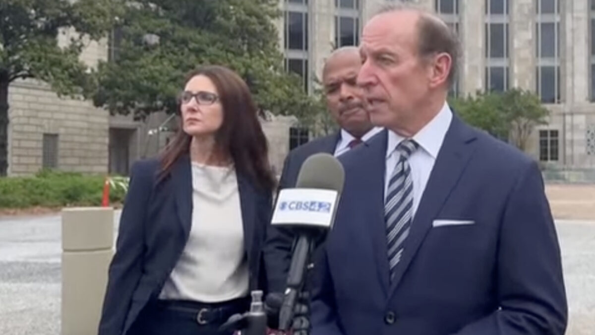 SPLC Abbe Lowell, a pinch-faced puritanical wokescold, scowls into a microphone in an outdoor press conference.