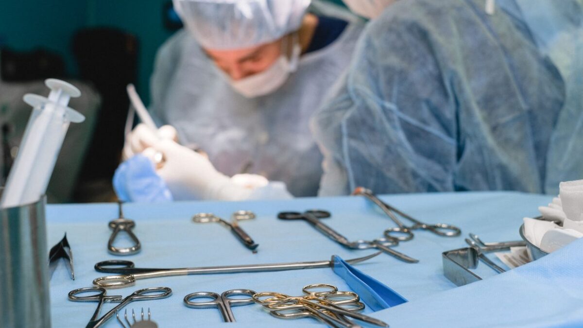 tray of scalpels and scissors with doctor in background