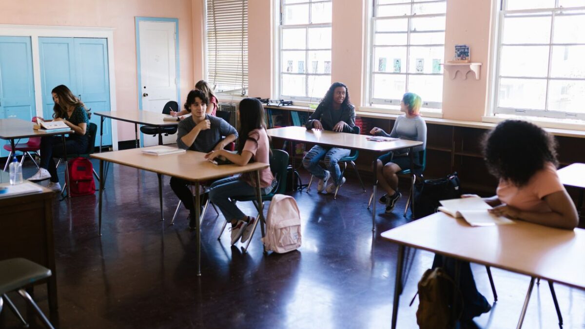 students talking at tables in a classroom
