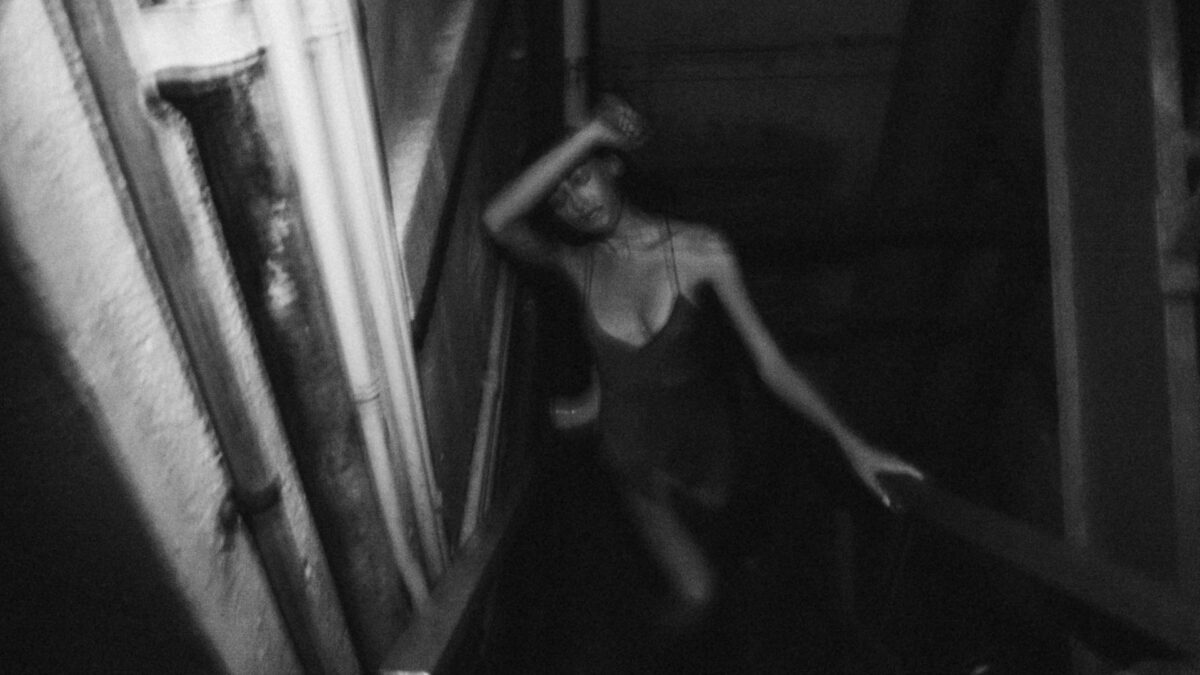 blurry photo of woman in tight dress coming upstairs
